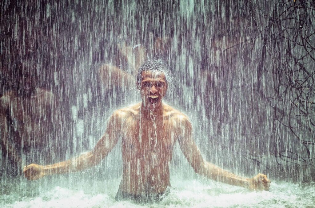 Adult man in a cold waterfall